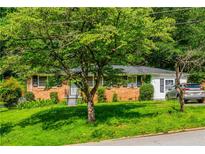 Charming single-story brick home featuring a lush, green lawn and mature trees for added privacy and curb appeal at 379 Utoy Sw Cir, Atlanta, GA 30331