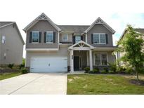 Charming two-story home with a well-manicured lawn and a two-car garage at 7753 Hansel Ln, Lithonia, GA 30058