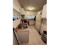 View of a kitchen with linoleum flooring, white cabinets, and stainless steel sink at 1750 Beechwood Sw Blvd, Atlanta, GA 30311