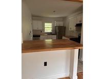 Charming kitchen featuring white cabinets, stainless steel appliances, wood countertops and a bright window at 2037 Brannen Se Rd, Atlanta, GA 30316