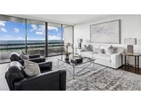 Bright living room featuring large windows, a balcony, and a comfortable seating area with modern decor at 2660 Peachtree Nw Rd # 23A, Atlanta, GA 30305