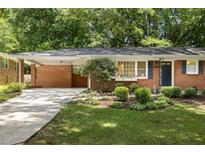 Charming brick home featuring a covered carport, complemented by a beautifully landscaped front yard at 1597 Fama Ne Dr, Atlanta, GA 30329