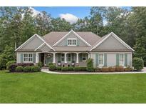Charming single-story home featuring a manicured lawn and a welcoming front porch with rocking chairs at 208 Wilshire Ter, White, GA 30184