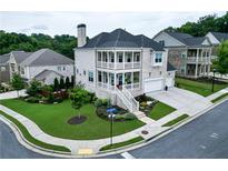Beautiful two-story brick home featuring dual porches, manicured lawn, attached garage, and professional landscaping at 4503 Atley Woods Se Dr, Atlanta, GA 30339