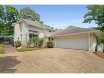 Charming home exterior with a two-car garage, landscaped yard, and a cozy outdoor seating area at 2610 Links End, Roswell, GA 30076