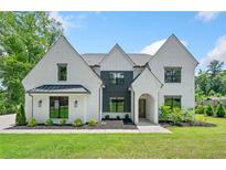 Stunning two-story white brick home with black-framed windows and manicured lawn at 103 Maddox Rd, Buford, GA 30518