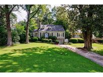 Charming home featuring manicured front lawn, beautiful landscaping, and inviting blue front door at 2811 Alpine Ne Rd, Atlanta, GA 30305