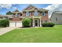 Charming two-story brick home featuring a well-manicured lawn and a two-car garage at 412 Middlebrooke St, Canton, GA 30115
