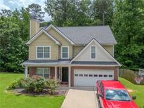 Charming two-story home with a brick and siding exterior, a well-manicured lawn, and an attached two-car garage at 5807 Mitchell Chase Trl, Mableton, GA 30126