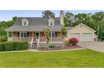 Charming two-story home with brick and siding, a covered porch, a two-car garage, and a well-maintained front yard at 1320 Pinyon Pl, Lawrenceville, GA 30043