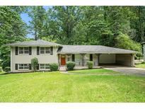 Charming split-level home with brick facade, manicured lawn, and covered carport nestled in lush greenery at 1534 Sw Austin Sw Rd, Atlanta, GA 30331