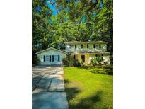 Charming two-story home featuring lush green lawn, classic black shutters, and lovely trees surrounding the property at 287 Willow Cove Ct, Lawrenceville, GA 30044