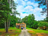 Charming two-story home with a well-manicured front yard and long driveway at 4086 Rex Road, Rex, GA 30273