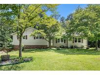 Charming home featuring a well-maintained lawn, mature trees, and a classic exterior at 2067 Skyhawk Ln, Acworth, GA 30102