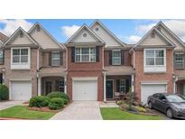 Attractive brick townhome with attached garage, manicured lawn, and charming front porch at 2377 Heritage Park Nw Cir # 16, Kennesaw, GA 30144