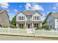 Charming two-story home featuring a white picket fence, landscaped yard, and inviting front porch at 3725 Downing Dr, Cumming, GA 30040