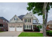 Stately brick home featuring a manicured lawn and a two-car garage at 4645 Wykeshire Ct, Cumming, GA 30041