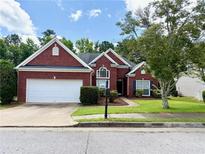 Charming brick home featuring a well-manicured lawn and a two-car garage at 4460 Greycliff Pte, Douglasville, GA 30135