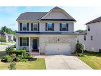 Charming two-story home with a brick facade, covered porch, and well-manicured landscaping at 4250 Pembia Dr, Cumming, GA 30028