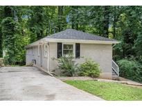 Ranch-style home surrounded by lush trees and features grey brick at 2721 Glenvalley Dr, Decatur, GA 30032