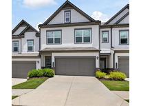 Charming townhome featuring a two-car garage and well-maintained landscaping at 320 Crider Ct, Woodstock, GA 30188