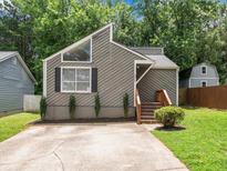 Charming home featuring a unique roofline, neutral siding, front window detail and inviting front steps at 4679 Candlewyck Way, Buford, GA 30518