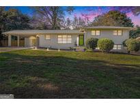 Charming brick home with a well-manicured lawn and covered parking area at 1151 Bromley Rd, Avondale Estates, GA 30002