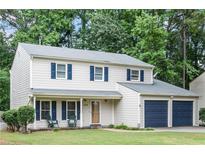Charming two-story home featuring a well-maintained lawn, dark blue shutters and a two-car attached garage at 440 Barrington W Dr, Roswell, GA 30076
