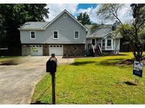 Charming two-story home featuring a well-manicured lawn, dual garage, and stone accents at 208 Arbour Way, Suwanee, GA 30024