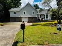 Charming home featuring a manicured lawn, stone accents, and a two-car garage at 208 Arbour Way, Suwanee, GA 30024