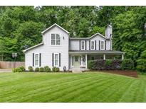 Charming two-story home features a covered porch, green door, basketball court, and lush front yard at 361 Princeton Way, Lawrenceville, GA 30044