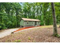 Charming single-story home nestled in a lush, wooded lot offering both privacy and curb appeal at 3992 Joshua Ln, Douglasville, GA 30135