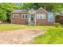 Charming brick home with a cozy front porch and spacious front yard perfect for outdoor activities at 879 Sylvan Sw Pl, Atlanta, GA 30310