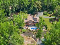 Stunning aerial view of a private home featuring an in-ground pool surrounded by lush landscaping and mature trees at 1572 Azalea Dr, Lawrenceville, GA 30043