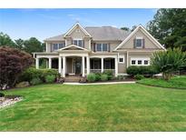 Charming home with a large, manicured lawn, covered front porch, and inviting curb appeal at 32 Pullman Trl, Acworth, GA 30101
