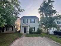 Charming two-story home featuring a cozy front porch, and a spacious driveway surrounded by mature trees at 241 Coral Cir, Mcdonough, GA 30253