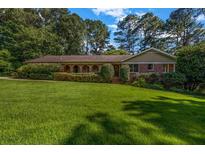 Charming brick home with a lush green lawn and mature trees offering great curb appeal at 2585 Regency E Dr, Tucker, GA 30084
