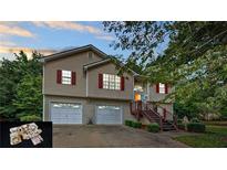 Charming split-level home with two-car garage and inviting front porch with red shutters at 310 Willow Ln, Temple, GA 30179