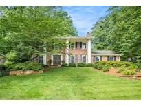 Charming two-story brick home with a lush green lawn and mature trees at 1691 Houghton N Ct, Atlanta, GA 30338