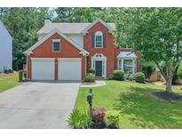 Charming two-story brick home featuring a manicured lawn and a two-car garage at 508 Keeneland Ave, Woodstock, GA 30189