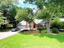 Charming brick home featuring an attached garage, well-maintained lawn, and mature trees providing ample shade at 4819 Coppedge Trl, Peachtree Corners, GA 30096