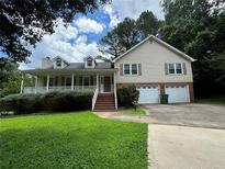 Charming home with front porch, dormer windows, attached two-car garage and well-maintained lawn at 2936 Highland Park Dr, Stone Mountain, GA 30087