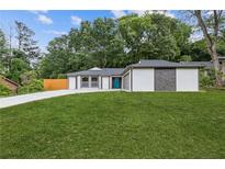 Charming home featuring a blue front door, stylish exterior, and a well-maintained green lawn at 1272 Sherwood Dr, Norcross, GA 30093
