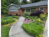 Charming brick home with well-manicured landscaping, walkway, and American flag at 2628 Tanglewood Rd, Decatur, GA 30033