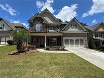 Charming two-story home features brick and stone accents, a two-car garage, and a well-maintained front yard at 3270 Arbor Oaks Dr, Snellville, GA 30039