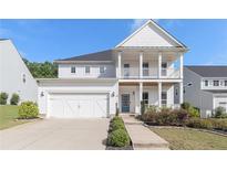Charming two-story home featuring a welcoming front porch and a two-car garage at 129 Academy Ln, Canton, GA 30114