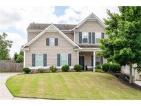 Charming two-story home featuring manicured lawn and stone-accented landscaping at 207 Cross Rd, Acworth, GA 30102
