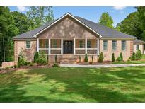 Charming brick home featuring a manicured lawn and inviting front porch, perfect for relaxing outdoors at 332 Mount Zion Rd, Oxford, GA 30054