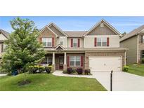 Charming two-story home featuring brick and siding, a well-manicured lawn, and an attached two-car garage at 6213 Old Kingston Dr, Atlanta, GA 30331
