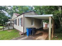 Cozy home featuring a convenient covered carport and charming curb appeal with lawn at 2430 Semmes St, Atlanta, GA 30344